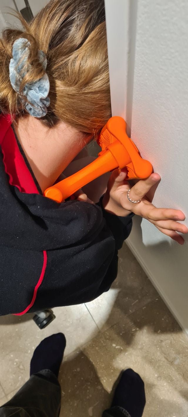 Person applying Mobilization Magic tool to front shoulder against wall to relieve tightness and improve shoulder mobility.