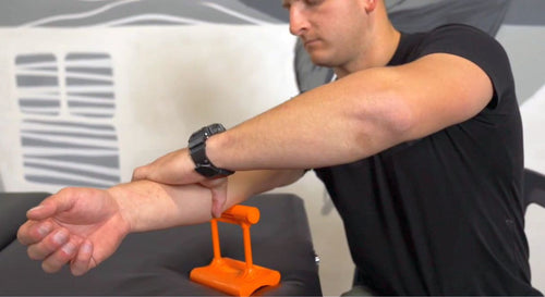 Man using Mobilization Magic™ tool to relieve elbow pain through arm extension technique.
